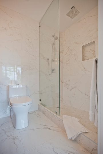 Marble tiles cover walls and floors in this bathroom